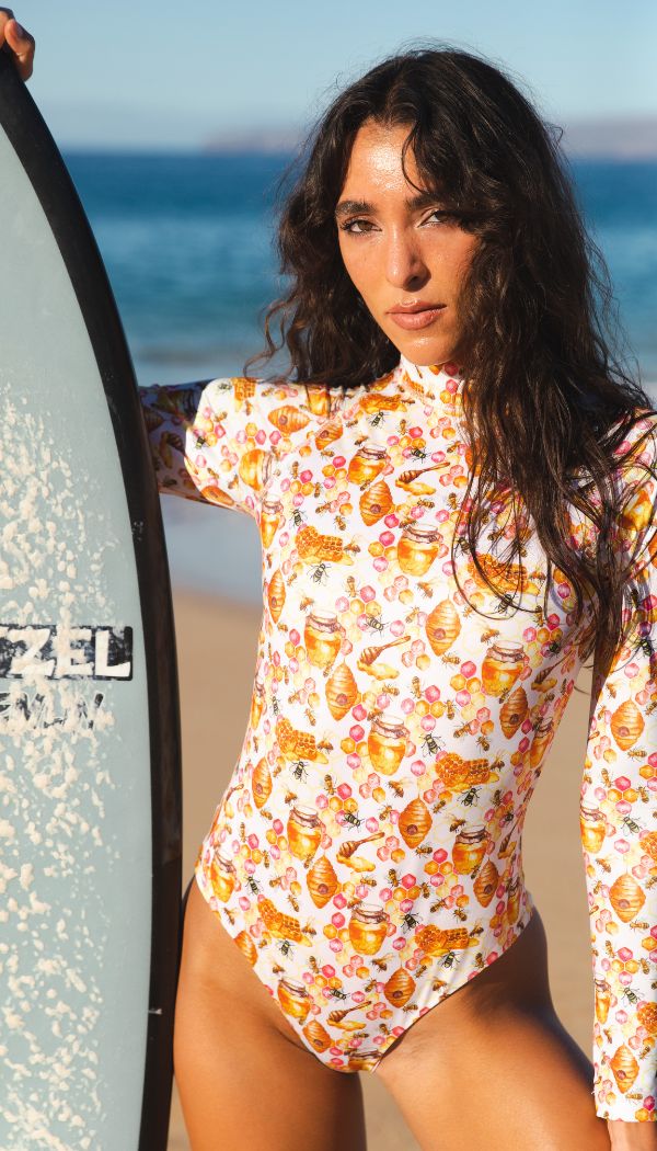 Model wearing long sleeve rashguard in honeycomb and bee print