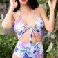 Woman wearing a colorful butterfly-patterned swimsuit outdoors.